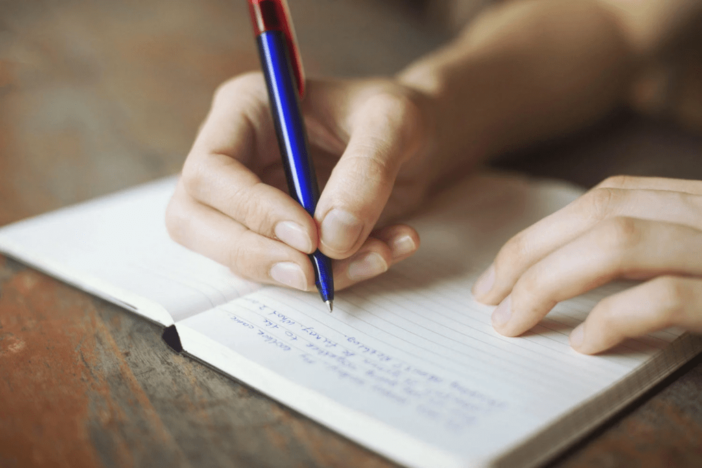 Student writing essay in notebook following clear academic structure